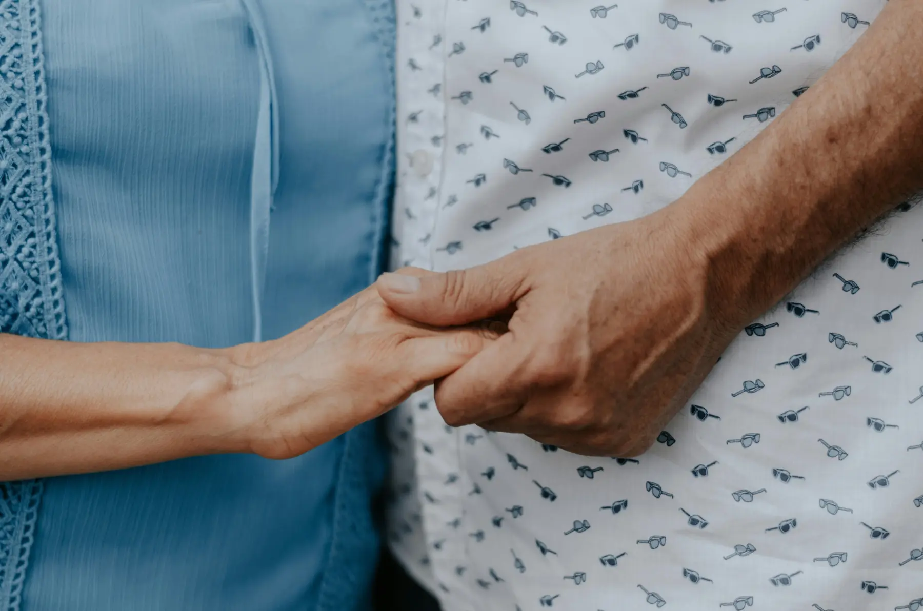 Caregiver gently holding the hands of an elderly client